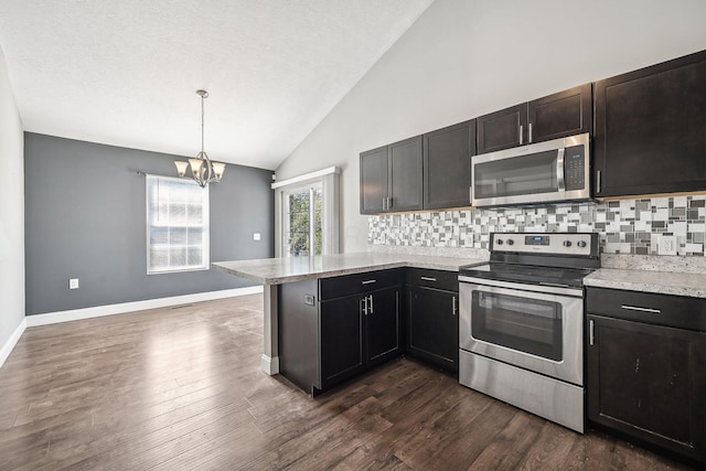 kitchen featuring pendant lighting, dark wood-type flooring, an inviting chandelier, appliances with stainless steel finishes, and kitchen peninsula