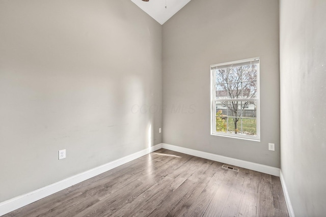 unfurnished room with ceiling fan, high vaulted ceiling, and wood-type flooring