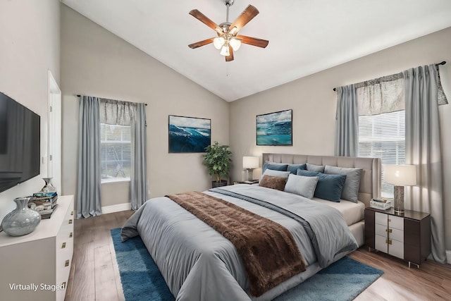 bedroom with multiple windows, ceiling fan, light hardwood / wood-style flooring, and high vaulted ceiling