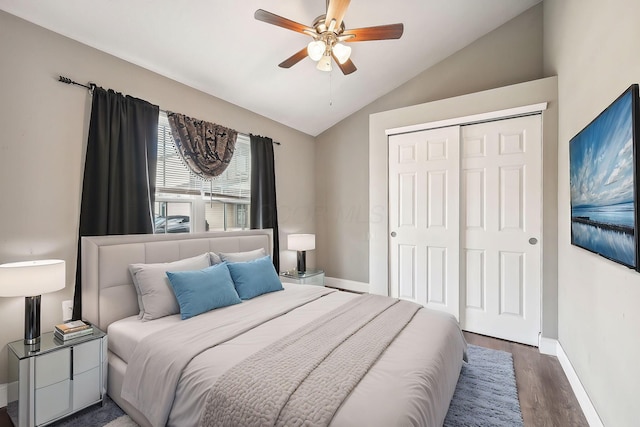 bedroom with ceiling fan, a closet, dark hardwood / wood-style flooring, and vaulted ceiling