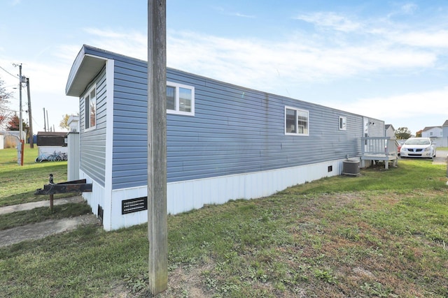 view of property exterior with central AC and a yard