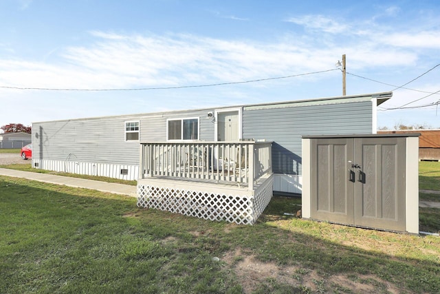 rear view of house with a storage unit and a lawn