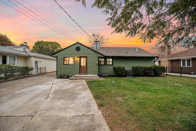 view of front of house featuring central AC unit and a lawn