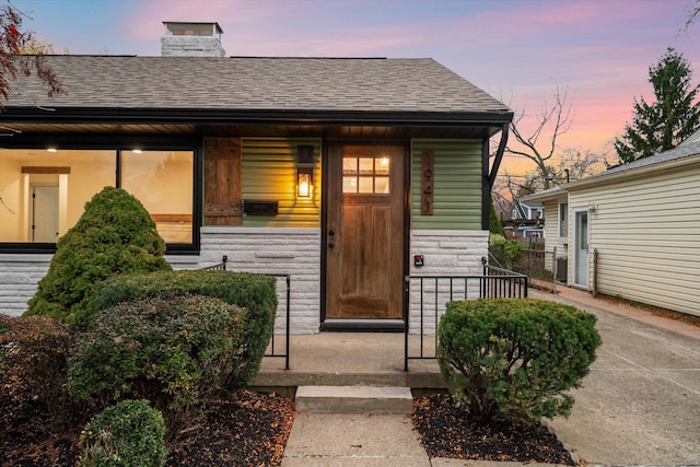 exterior entry at dusk with covered porch