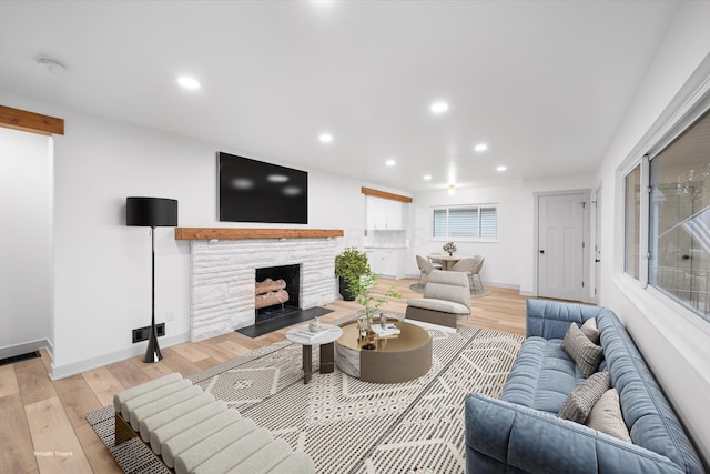 living room featuring a fireplace, light hardwood / wood-style flooring, and plenty of natural light