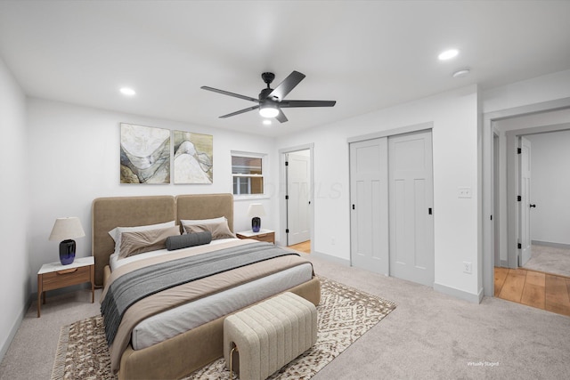 bedroom featuring ceiling fan, light carpet, and a closet