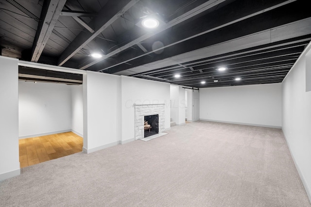 basement featuring carpet floors and a brick fireplace