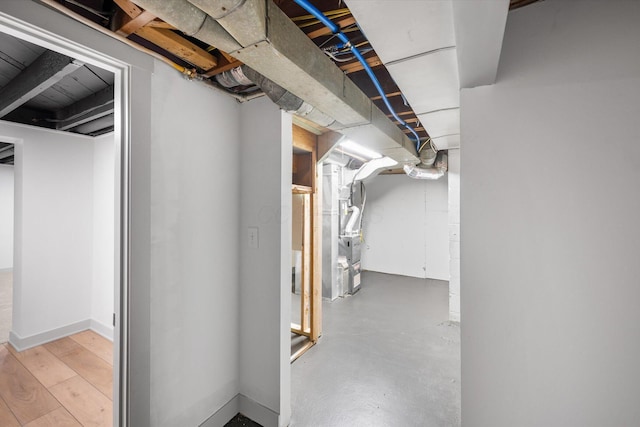 basement featuring heating unit and light hardwood / wood-style floors