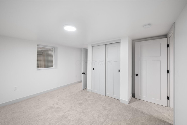 unfurnished bedroom with light colored carpet and a closet