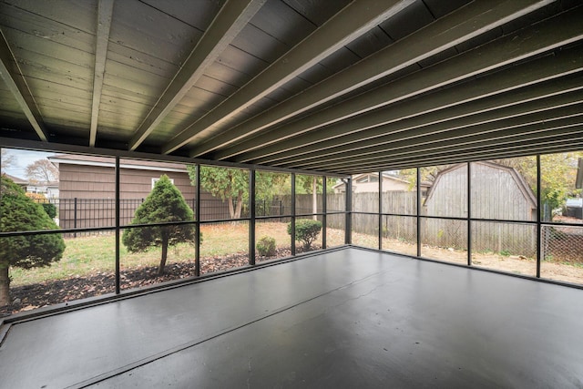 unfurnished sunroom featuring beamed ceiling