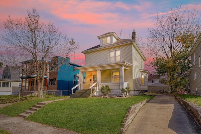 view of front of property featuring covered porch and a yard