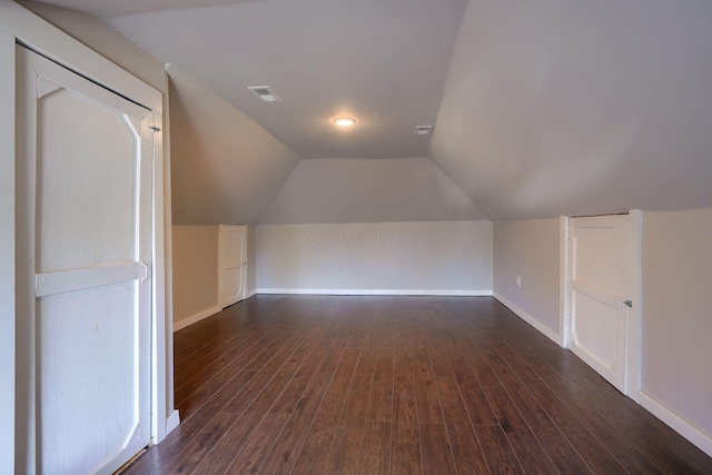 bonus room featuring dark hardwood / wood-style floors and vaulted ceiling