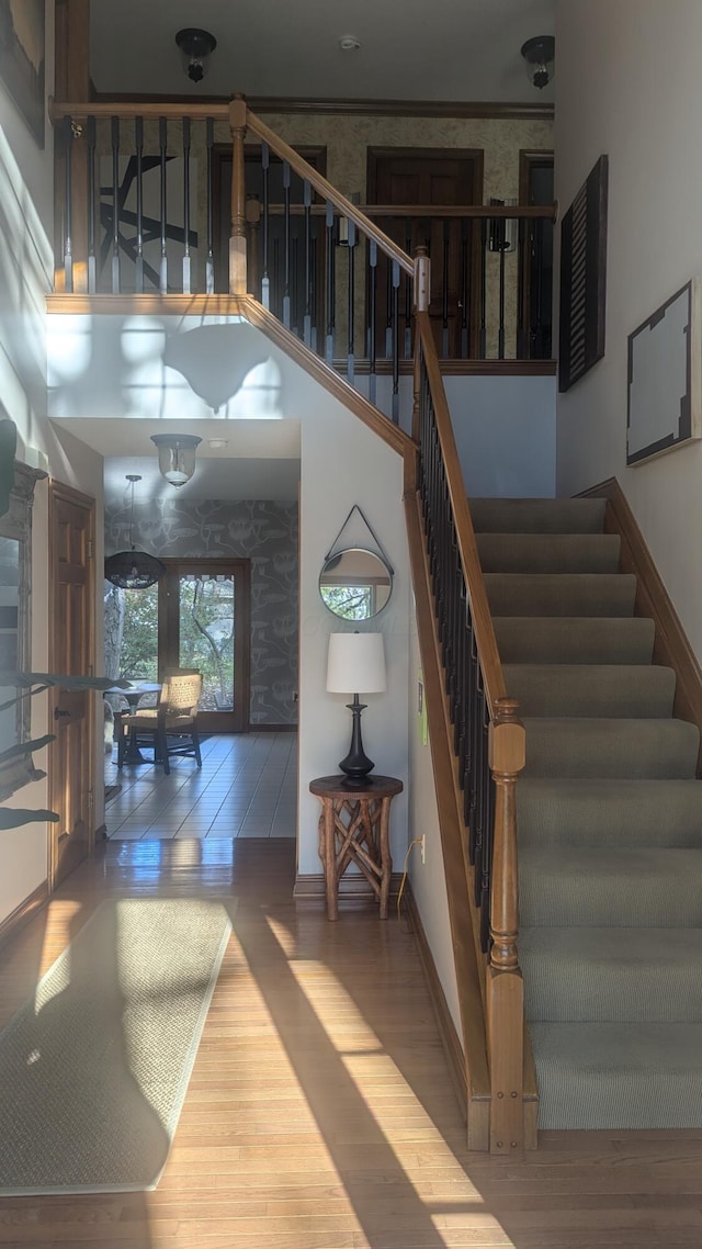 stairs with crown molding and hardwood / wood-style floors