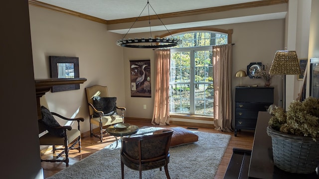 living area featuring a chandelier, hardwood / wood-style floors, and crown molding