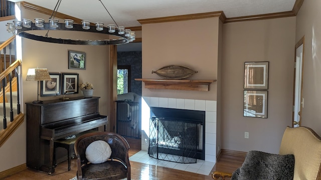 interior space featuring light hardwood / wood-style floors, crown molding, and a tiled fireplace