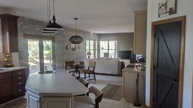 kitchen featuring pendant lighting, sink, light tile patterned floors, and a healthy amount of sunlight