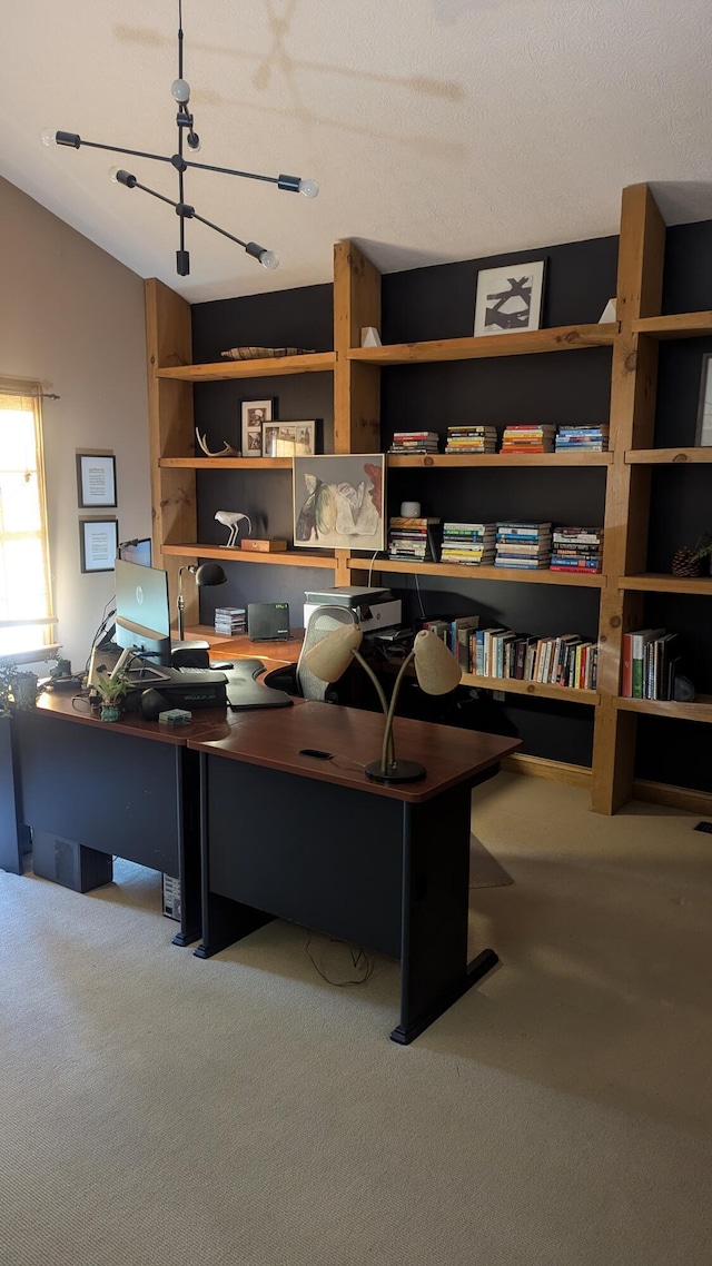 office area with carpet, a textured ceiling, vaulted ceiling, and an inviting chandelier