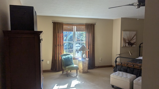 carpeted bedroom featuring ceiling fan and a textured ceiling