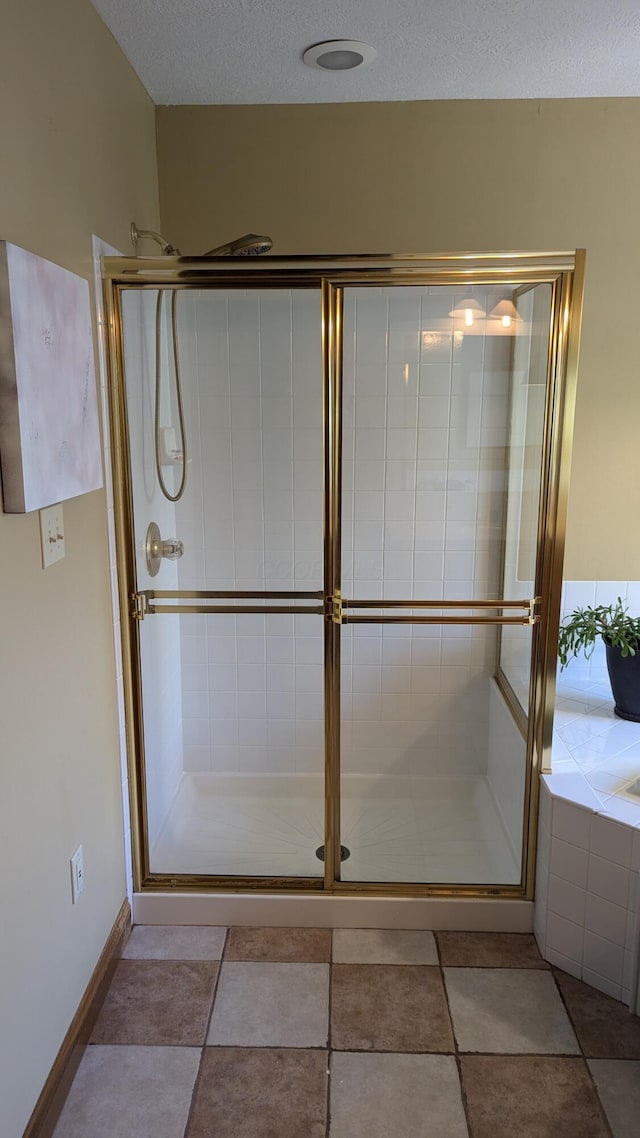 bathroom featuring an enclosed shower and a textured ceiling