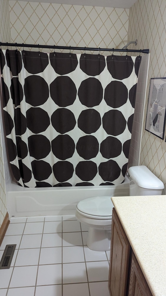 full bathroom featuring toilet, vanity, tile patterned floors, and shower / bathtub combination with curtain