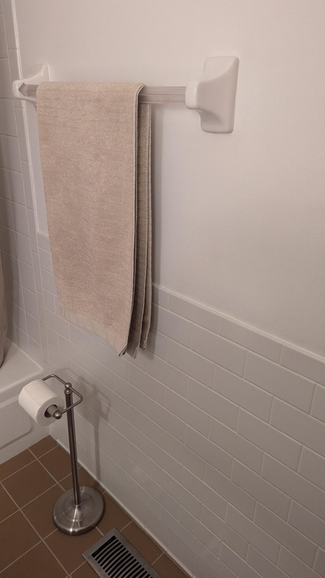 bathroom with tile patterned flooring,  shower combination, and tile walls