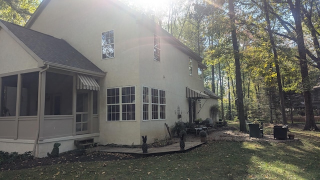 view of side of home featuring a lawn and a sunroom