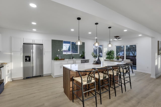 kitchen featuring white cabinets, a large island, pendant lighting, and appliances with stainless steel finishes