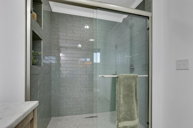 bathroom featuring vanity, an enclosed shower, and ornamental molding