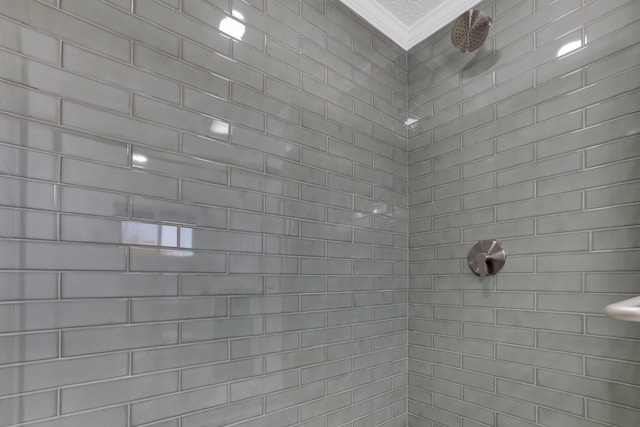 bathroom featuring crown molding and tiled shower