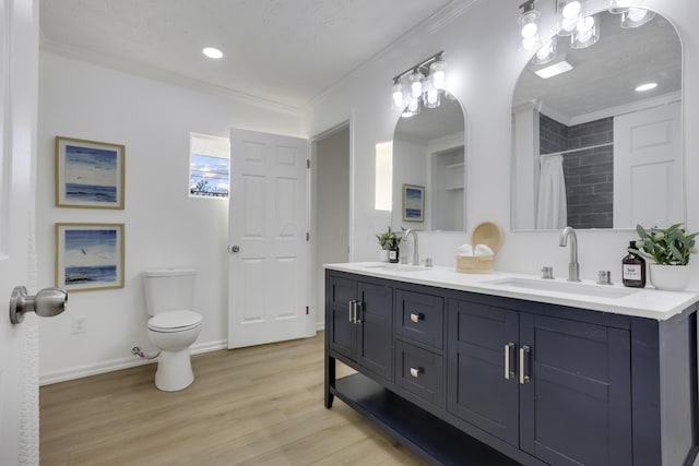 bathroom with crown molding, hardwood / wood-style floors, vanity, and toilet