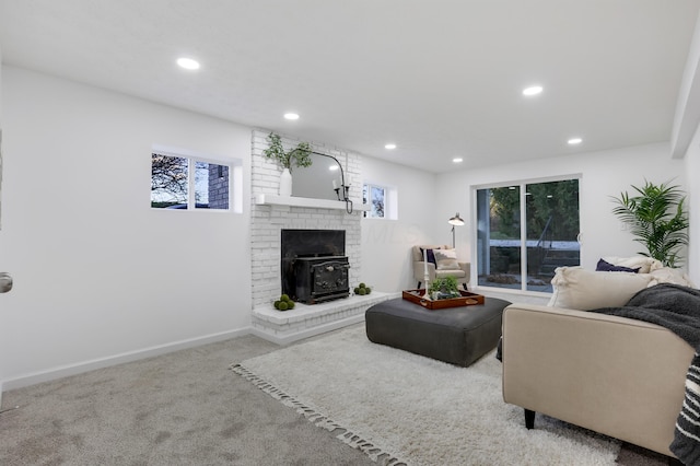 carpeted living room with a wood stove