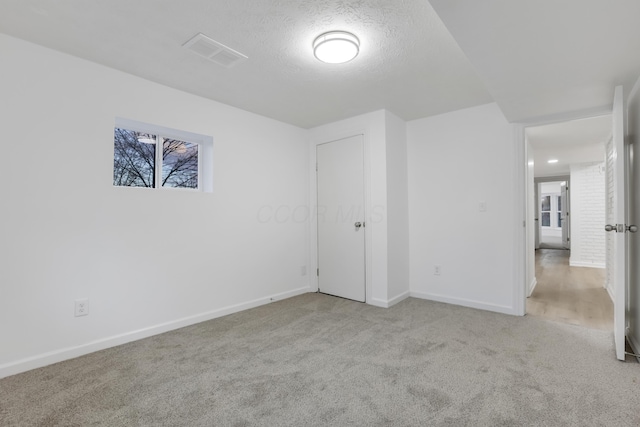 carpeted spare room featuring a textured ceiling