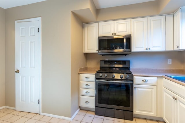 kitchen featuring light tile patterned flooring, white cabinetry, and appliances with stainless steel finishes