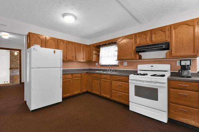 kitchen with backsplash, white appliances, sink, and a textured ceiling