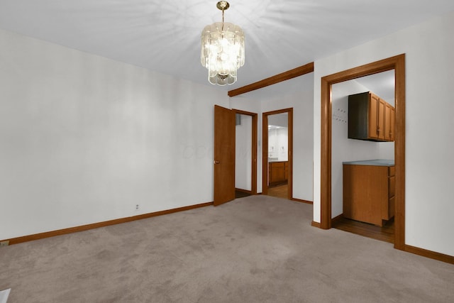 empty room with light carpet and an inviting chandelier