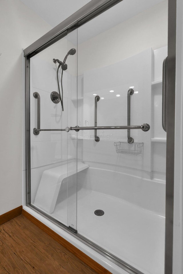 bathroom featuring hardwood / wood-style floors and a shower with door