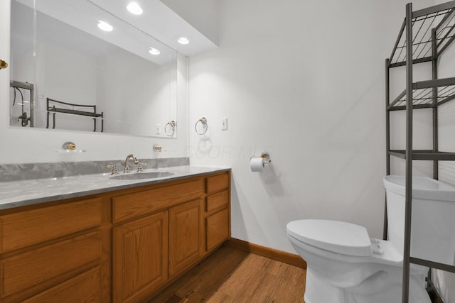 bathroom with hardwood / wood-style flooring, vanity, and toilet