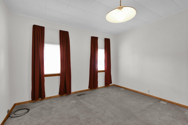 carpeted spare room featuring plenty of natural light