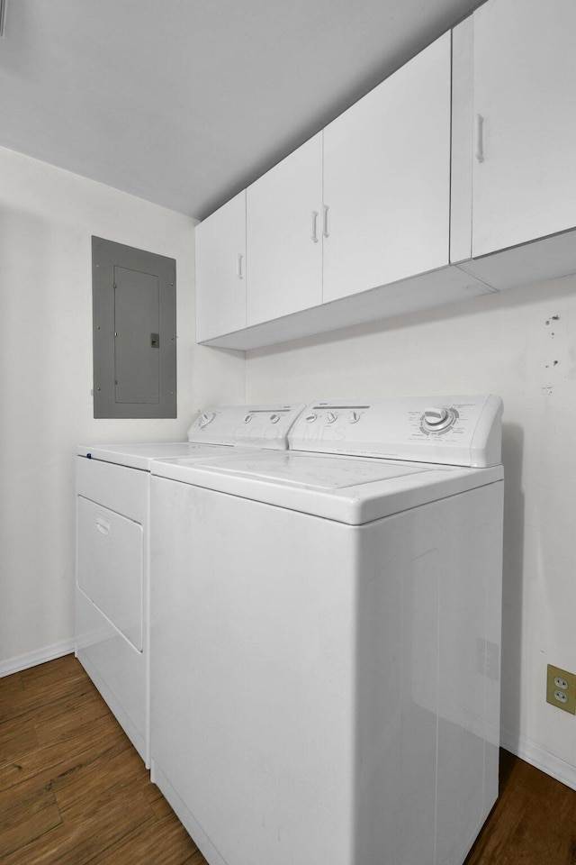 laundry room featuring washer and dryer, dark hardwood / wood-style flooring, electric panel, and cabinets