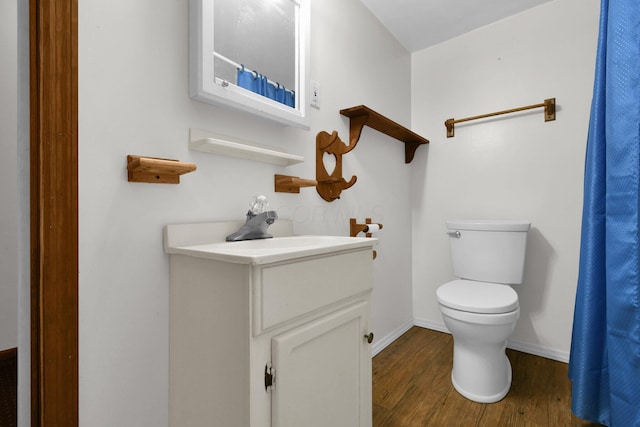 bathroom with hardwood / wood-style flooring, vanity, and toilet