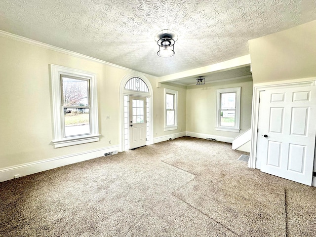 foyer featuring carpet flooring, crown molding, and a textured ceiling