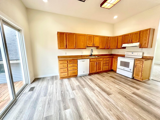 kitchen featuring white appliances, light hardwood / wood-style floors, and sink