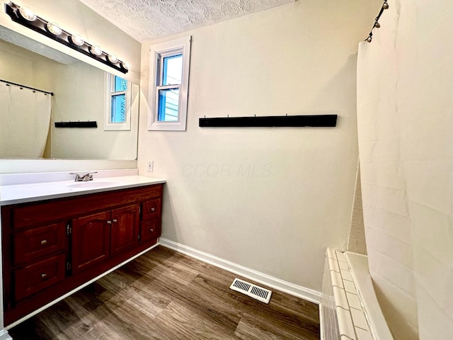 bathroom with hardwood / wood-style floors, vanity, a textured ceiling, and a shower with shower curtain