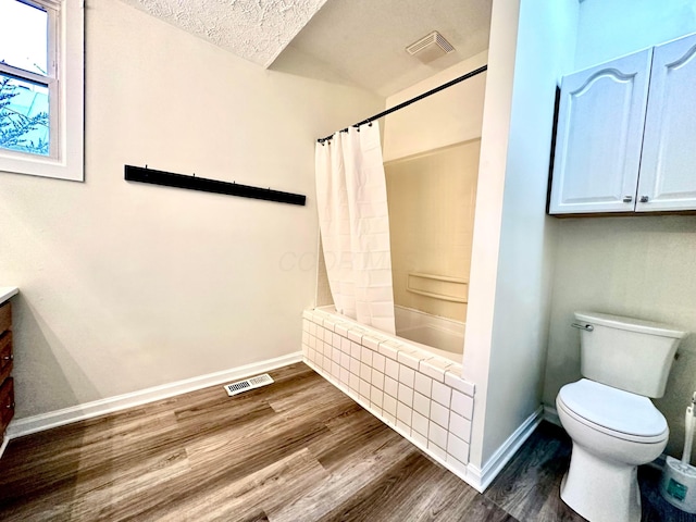 full bathroom featuring toilet, a textured ceiling, hardwood / wood-style flooring, and shower / tub combo with curtain