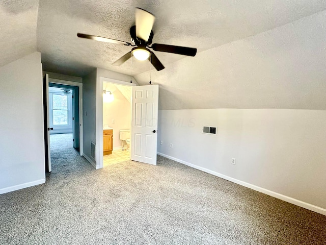 additional living space with ceiling fan, lofted ceiling, a textured ceiling, and light carpet