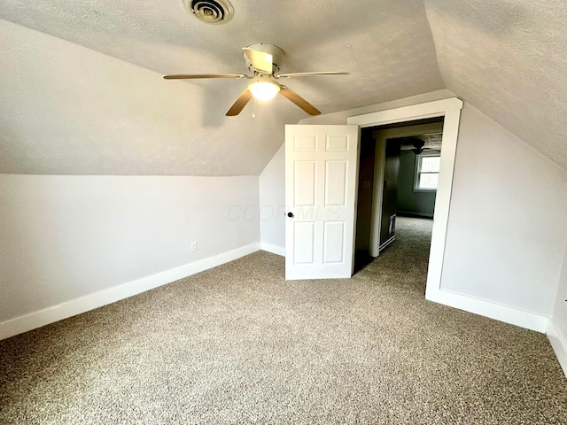 additional living space with carpet flooring, ceiling fan, lofted ceiling, and a textured ceiling