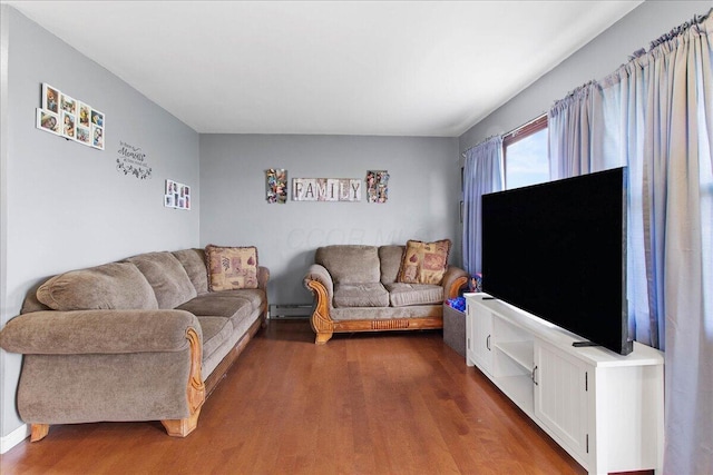 living room with dark wood-type flooring and a baseboard heating unit