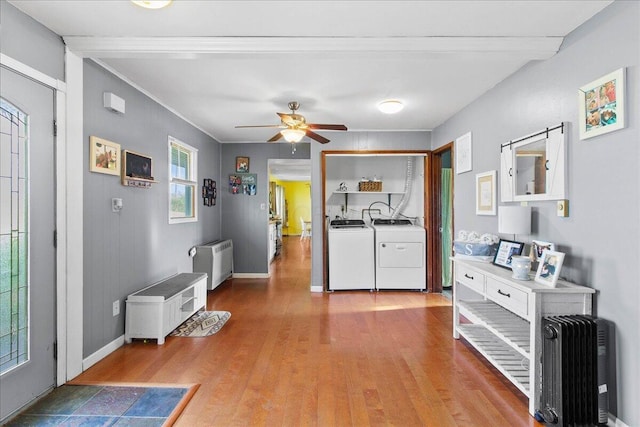 foyer featuring ceiling fan, radiator heating unit, crown molding, washer and dryer, and light wood-type flooring