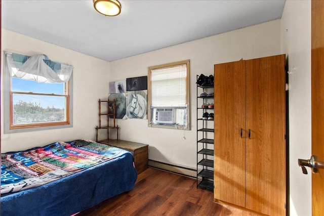 bedroom with cooling unit, baseboard heating, and dark wood-type flooring