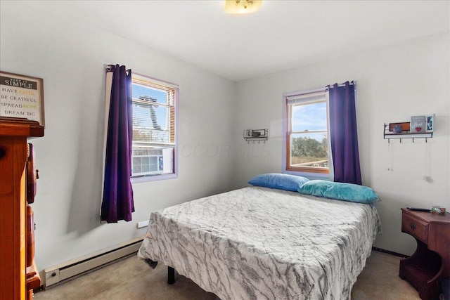 bedroom with multiple windows, light carpet, and a baseboard heating unit